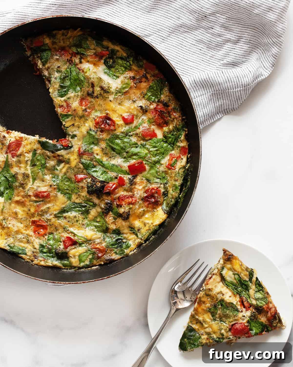 Vibrant Roasted Vegetable Egg White Frittata 7 A delicious roasted vegetable frittata remaining in a skillet, with a single perfect slice served on a plate next to it.