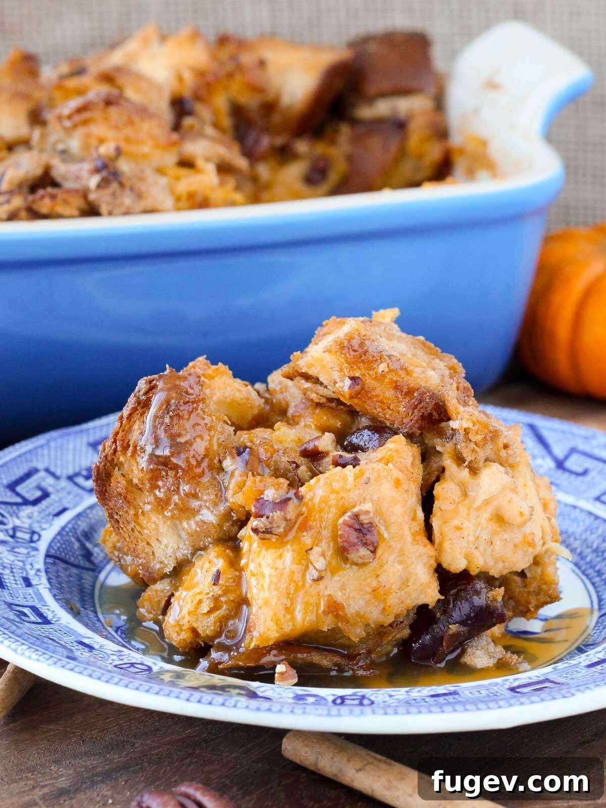 Cozy Pumpkin Bread Pudding 4 Pumpkin bread pudding served on a blue plate with bourbon sauce, set against a rustic wooden background.