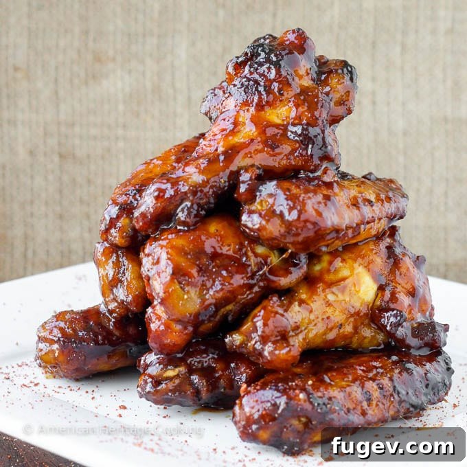 Sticky Sweet Chili Baked Wings 3 A pile of baked chicken wings glistening in a perfectly thick, ruby-red chipotle maple sauce.