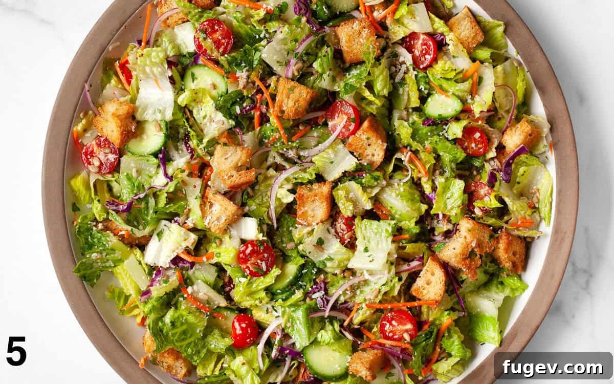 Garden Fresh Salad 6 A vibrant house salad, perfectly tossed with a red wine vinaigrette, filling a large mixing bowl.