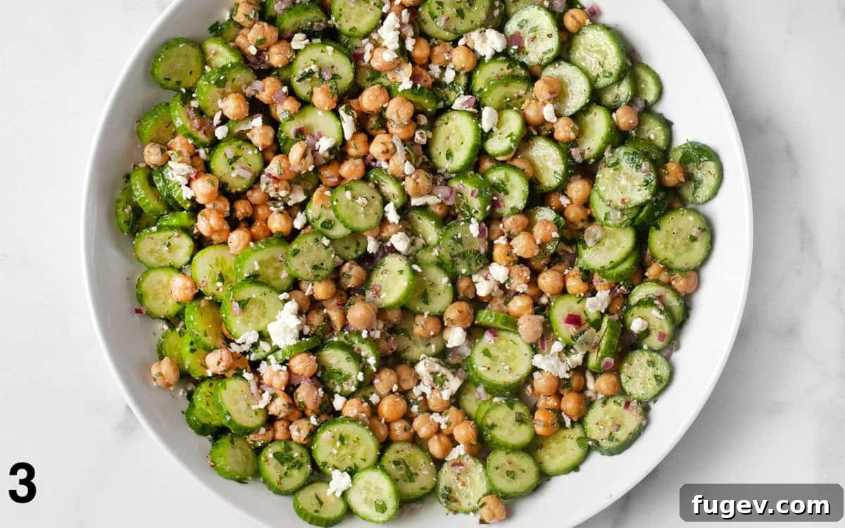 Mediterranean Chickpea Cucumber Refresh 5 The chickpea cucumber salad, now fully tossed with the red wine vinaigrette, in a large mixing bowl, ready to be served.