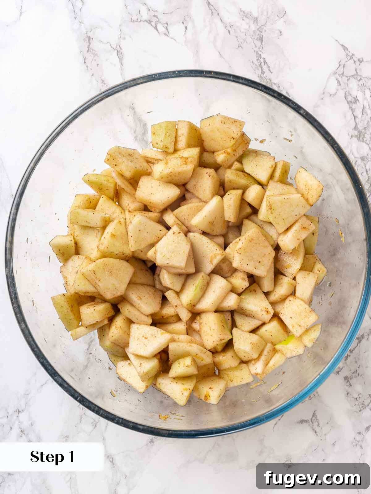 Effortless Apple Crisp Perfection 5 Sliced apples mixed with spices and sugar in a bowl, ready for the crisp filling.