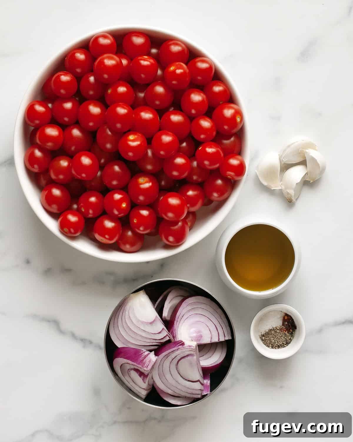 Bursting Roasted Cherry Tomato Sauce 3 A vibrant collection of ingredients including cherry tomatoes, onions, garlic, olive oil, and seasonings laid out on a board.