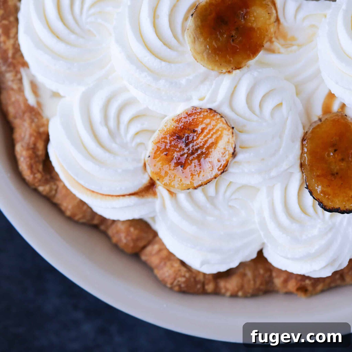 Pre-Bake Perfection: A Guide to Crisp Pie Crusts 12 A delicious banana cream pie adorned with elegant swirls of whipped cream, showcasing a perfectly stable and un-shrunk crust.