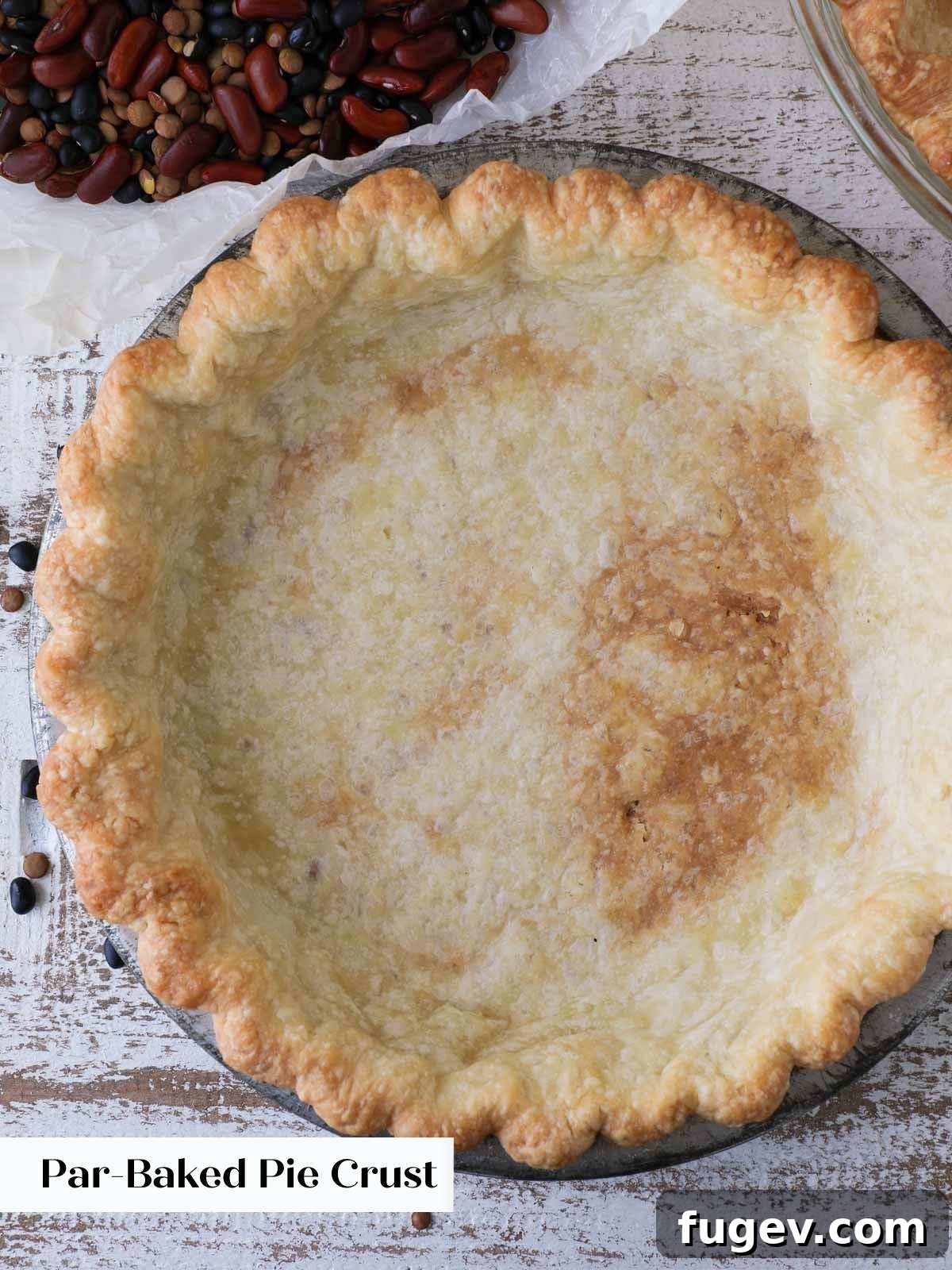 Pre-Bake Perfection: A Guide to Crisp Pie Crusts 10 A partially blind-baked pie crust still in its tin, showing minimal browning and readiness for the next step.