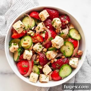A vibrant strawberry cucumber feta salad in a bowl, showcasing the fresh, colorful ingredients.