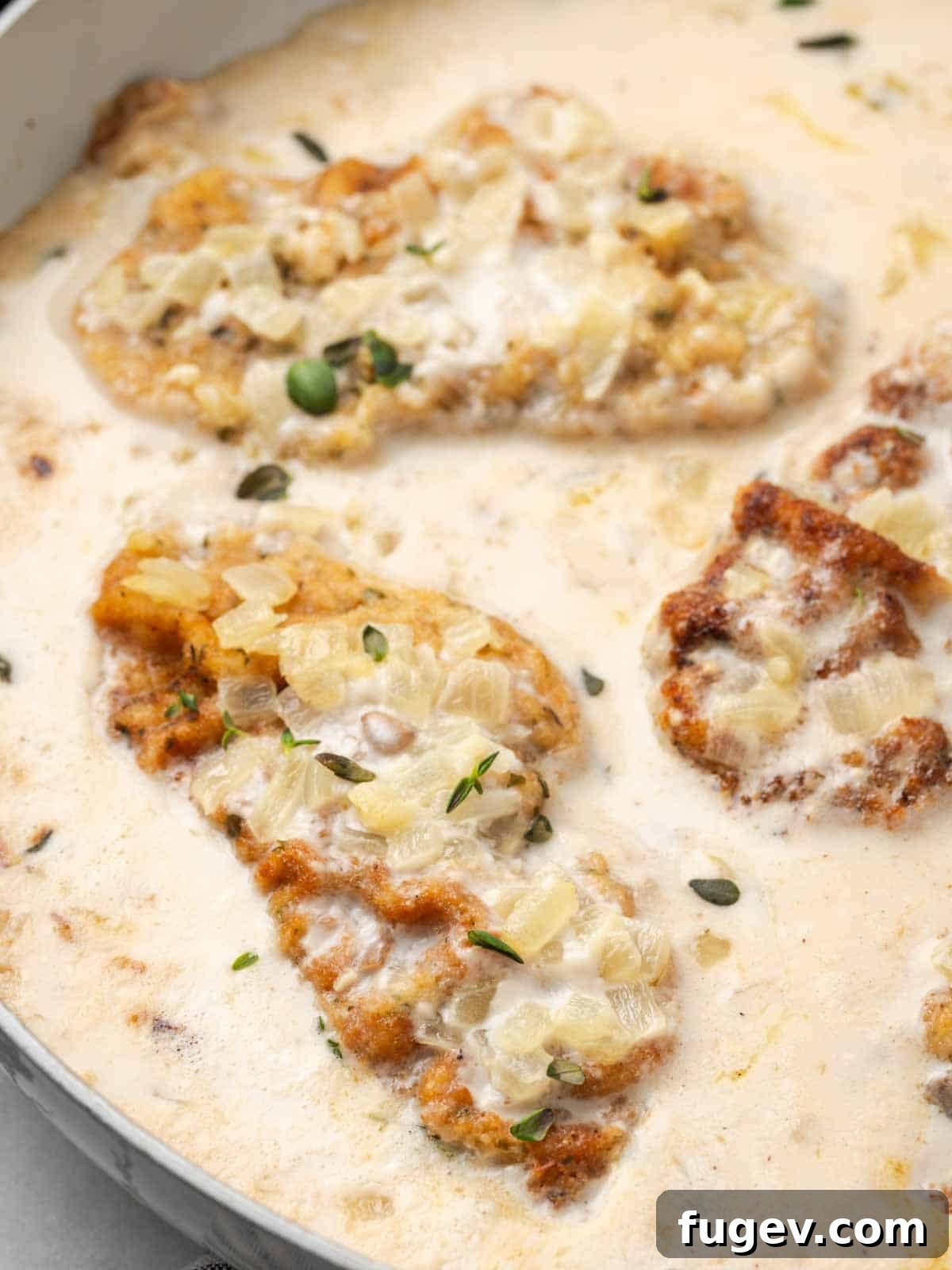 Creamy Mushroom Pork Chops 2 Golden-brown mushroom pork chop in a rich, creamy sauce, served in a pan.