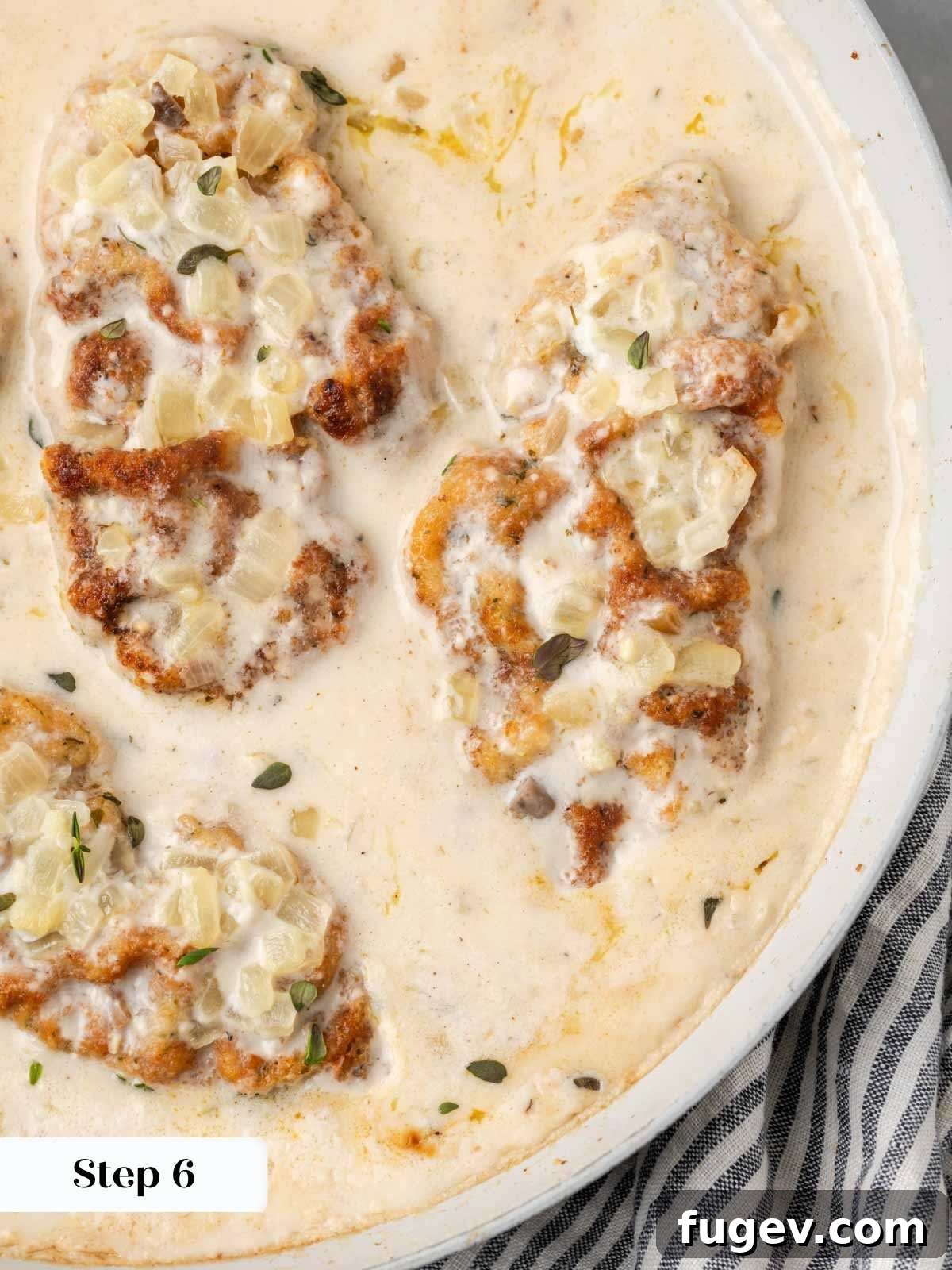 Creamy Mushroom Pork Chops 11 Fully cooked baked pork chops in a rich cream of mushroom soup sauce, garnished with fresh thyme, served in an oven-safe pan.