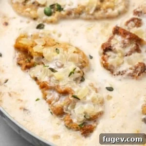 Perfectly cooked pork chop in a rich mushroom and thyme sauce, ready to serve.
