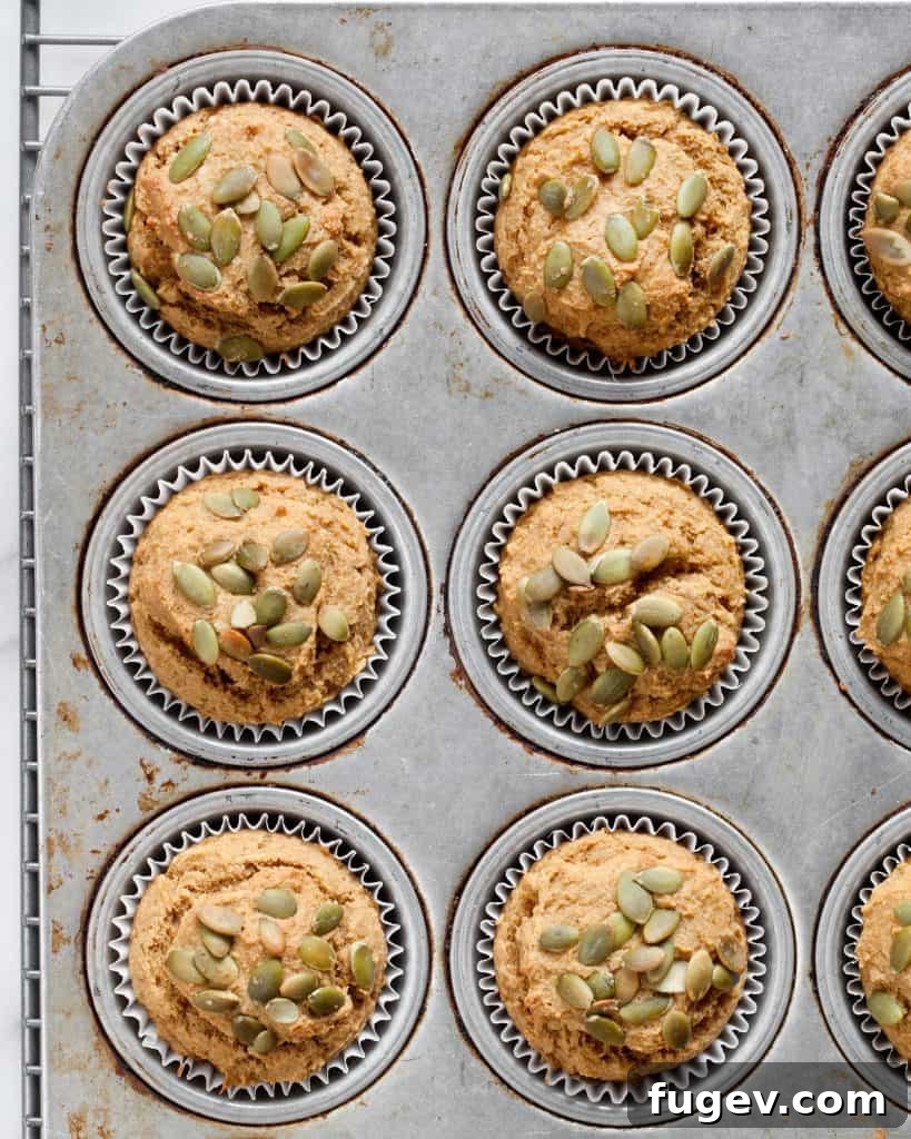 Golden Pumpkin Muffins 5 Freshly baked pumpkin muffins cooling in a muffin pan