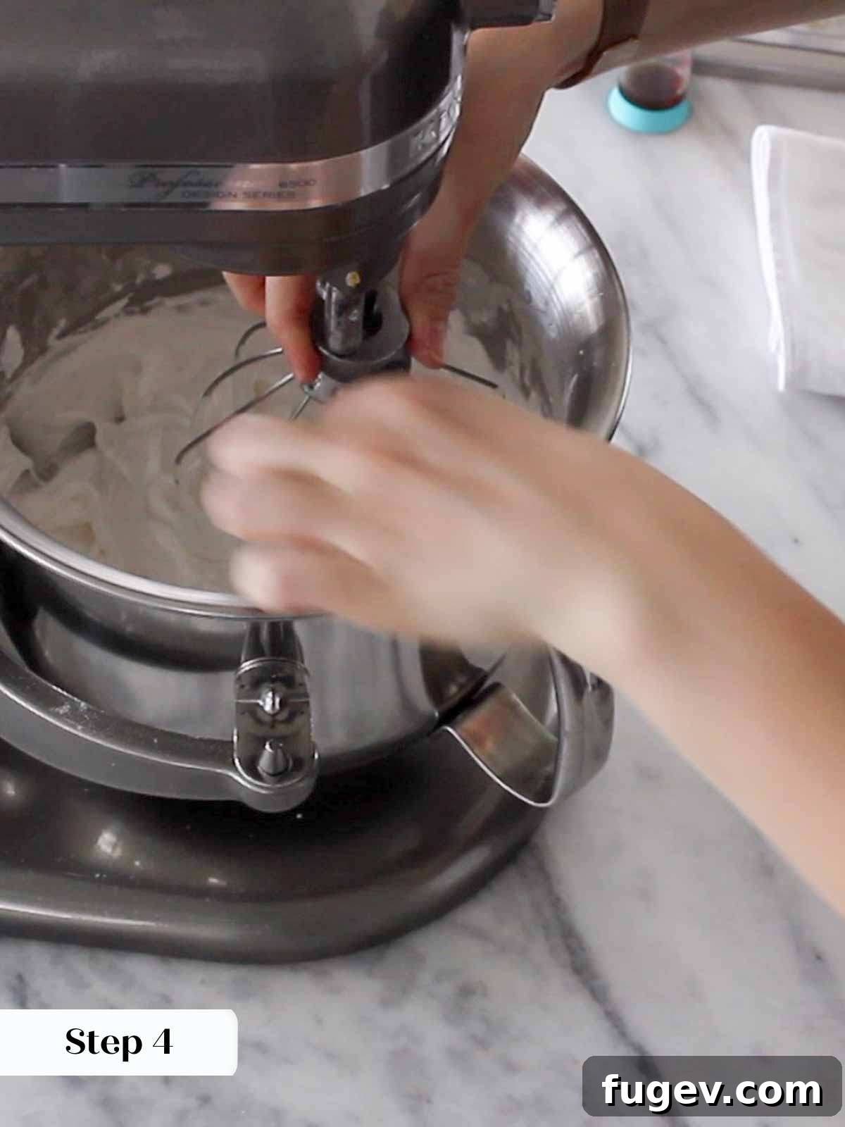 Pillowy Marshmallow Perfection 6 A stand mixer vigorously whipping meringue to achieve maximum volume and stiffness.