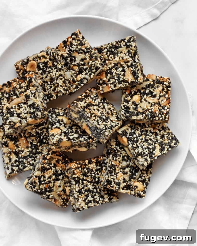 Golden Sesame Peanut Bars 4 Several Sesame Peanut Bars neatly stacked on a white plate