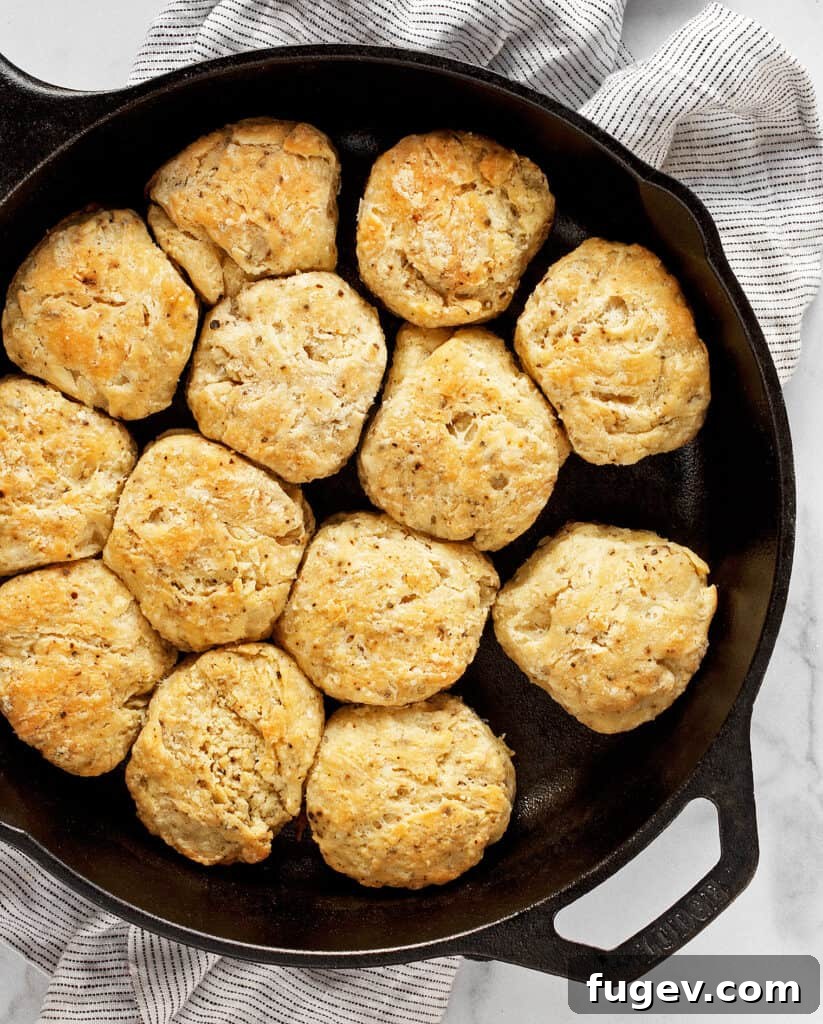 Salt and Pepper Biscuits 4 Biscuits baking in a round cast iron skillet, golden brown and rising beautifully