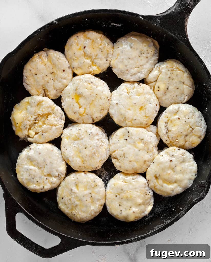 Salt and Pepper Biscuits 7 Melted butter being brushed onto the tops of unbaked biscuits in a skillet