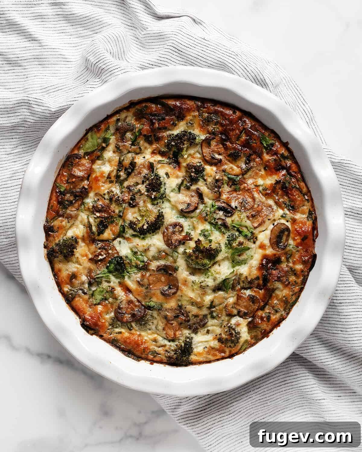 Wholesome Roasted Vegetable & Cottage Cheese Egg Casserole 2 A vibrant, golden-brown veggie egg bake cooling in a rustic pie dish, ready to be sliced.
