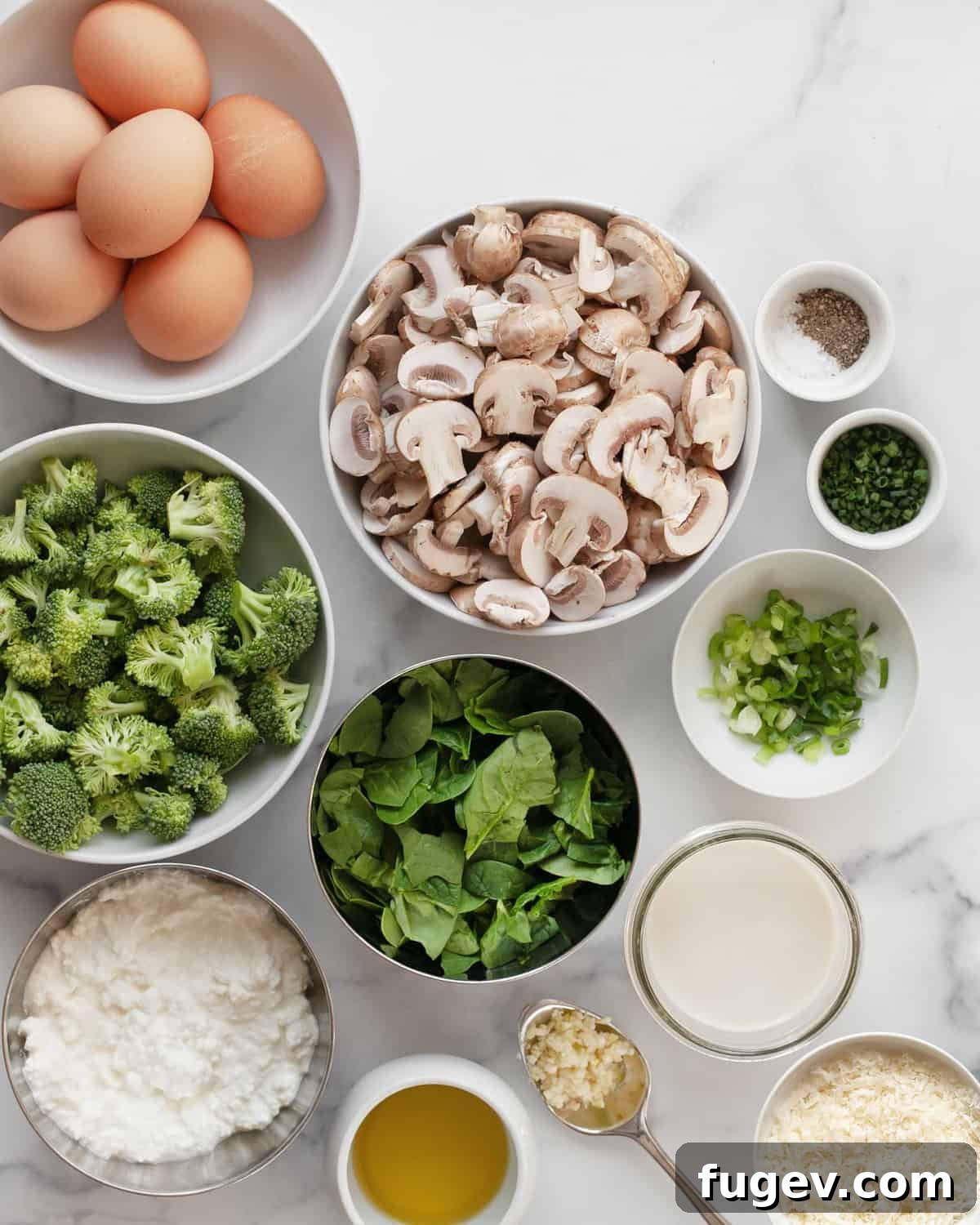 Wholesome Roasted Vegetable & Cottage Cheese Egg Casserole 3 A beautiful flat lay of fresh ingredients including vibrant green broccoli, earthy mushrooms, a carton of eggs, fresh spinach, bright scallions, chives, garlic, and a block of Parmesan cheese.