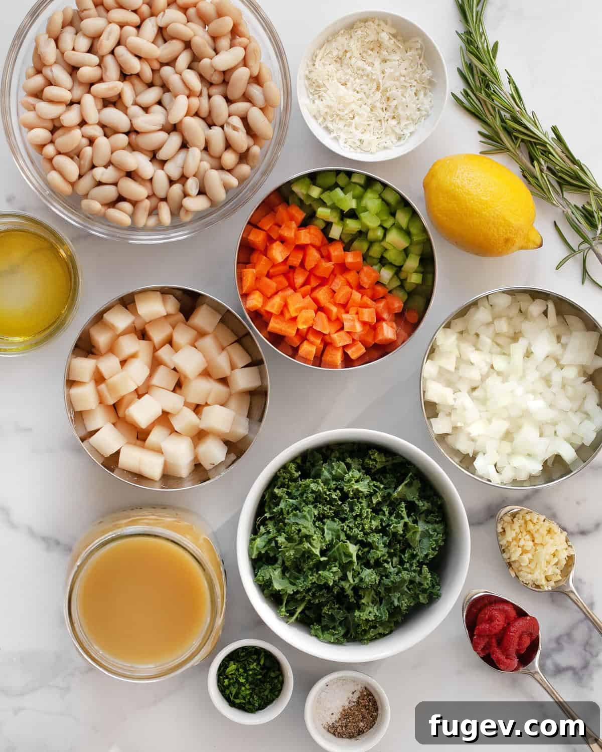 Velvety Tuscan White Bean Soup 3 Assortment of fresh ingredients for white bean soup, including cannellini beans, onions, carrots, celery, garlic, rosemary, and vegetable broth.