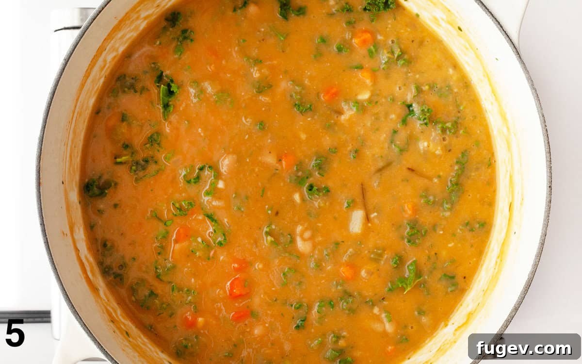 Velvety Tuscan White Bean Soup 6 White bean soup in the pot after kale, Parmesan, and herbs have been stirred in.