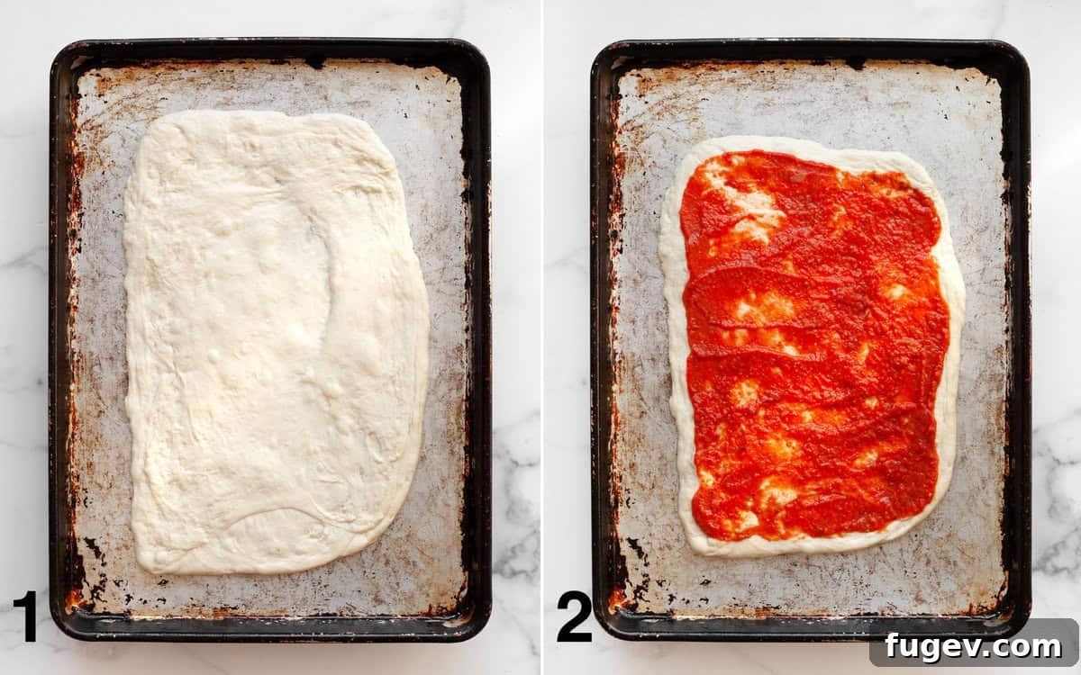 Mediterranean Harvest Pizza 4 Pizza dough rolled out on a baking pan with tomato sauce evenly spread across it.