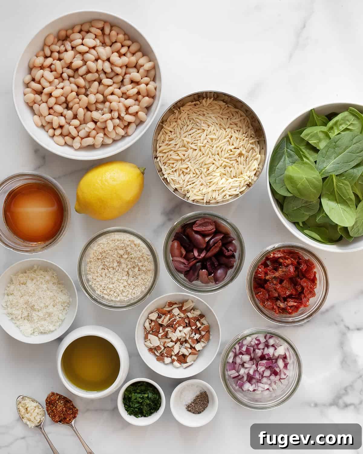Lemony Orzo Delight 3 Key ingredients for lemon orzo salad: fresh lemons, uncooked orzo, spinach, sun-dried tomatoes, Kalamata olives, white beans, olive oil, and garlic.