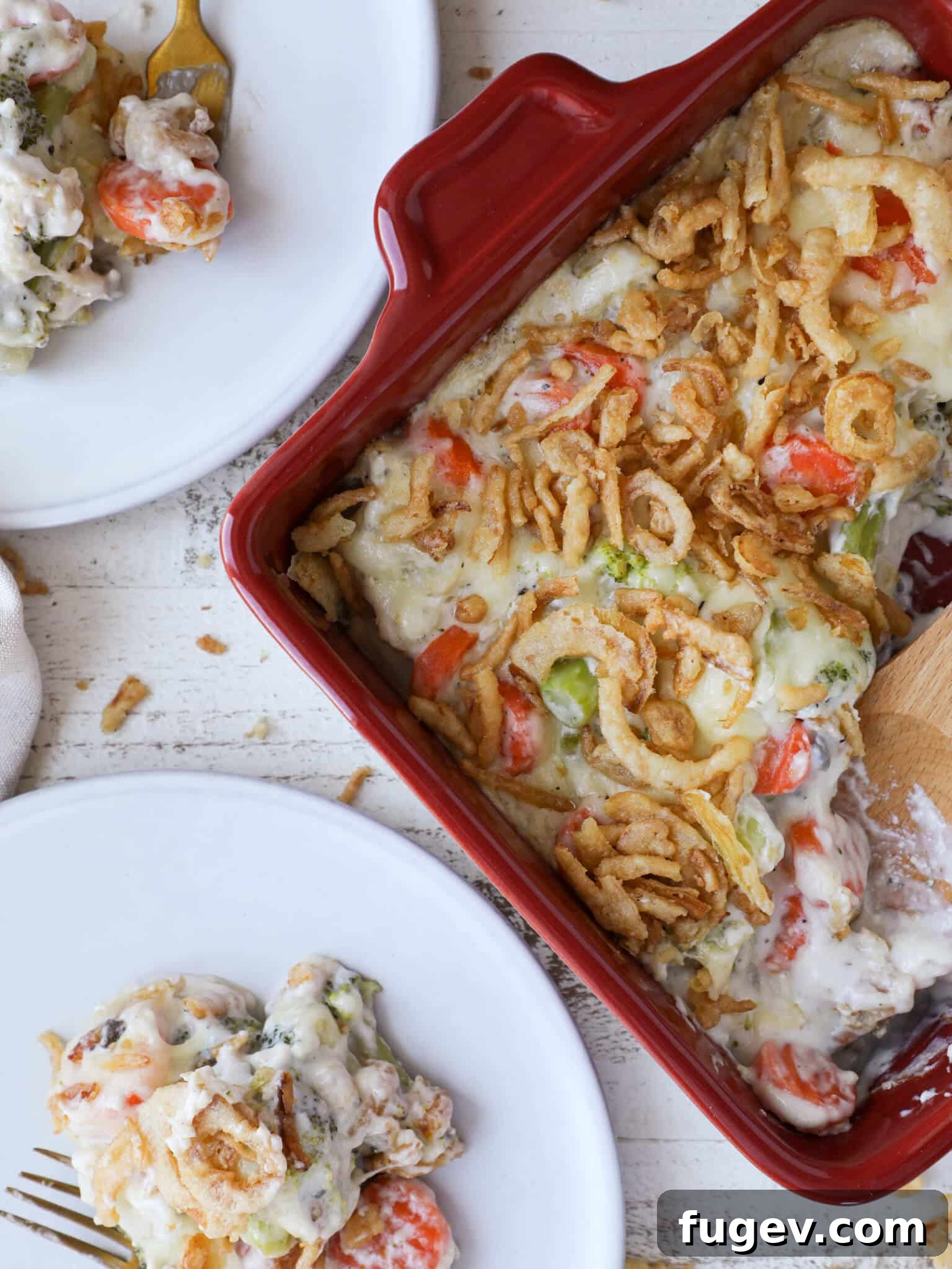 Hearty Vegetable Bake 2 Creamy Swiss Cheese Mixed Vegetable Casserole served in a vibrant red baking dish, accompanied by two pristine white plates, ready for sharing.