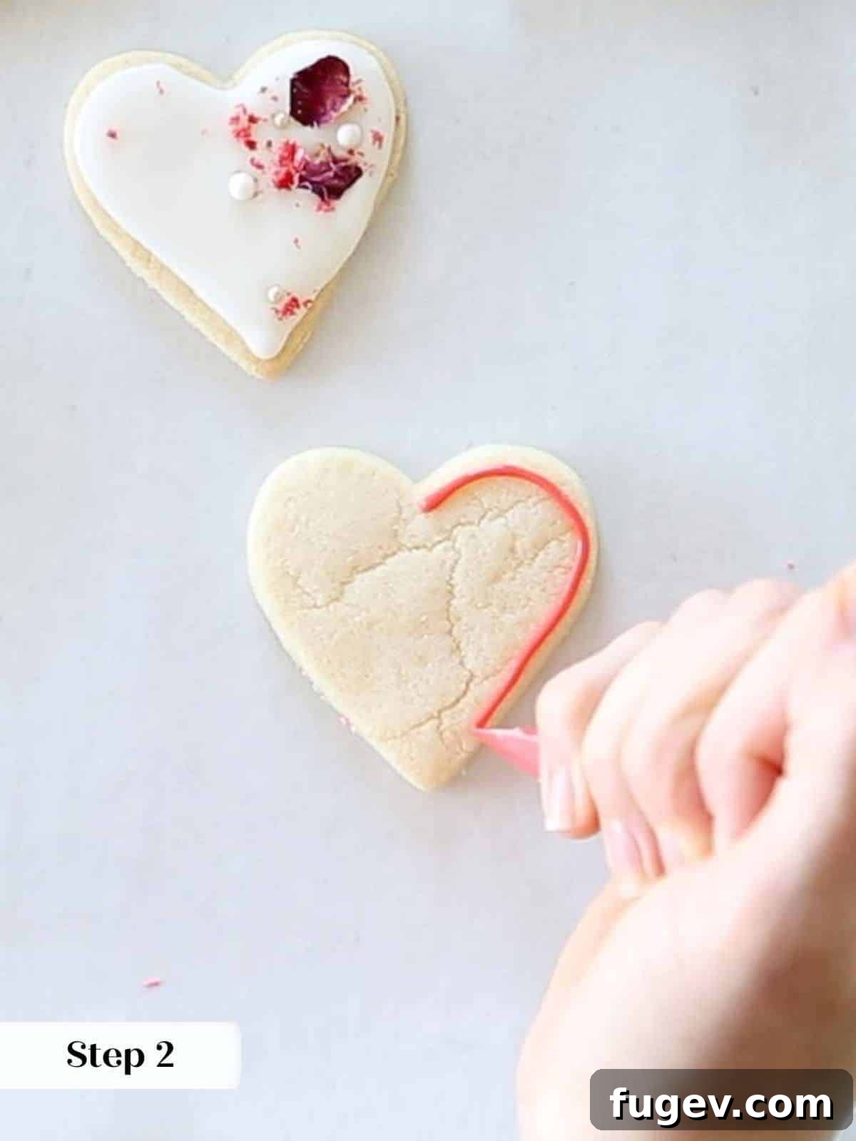 Cupid's Confections 11 Precisely outlining a sugar cookie with red royal icing using a piping bag.