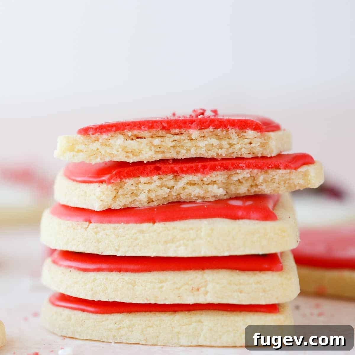 Cupid's Confections 4 Stack of iced sugar cookies, with one broken open to reveal its soft, chewy texture.