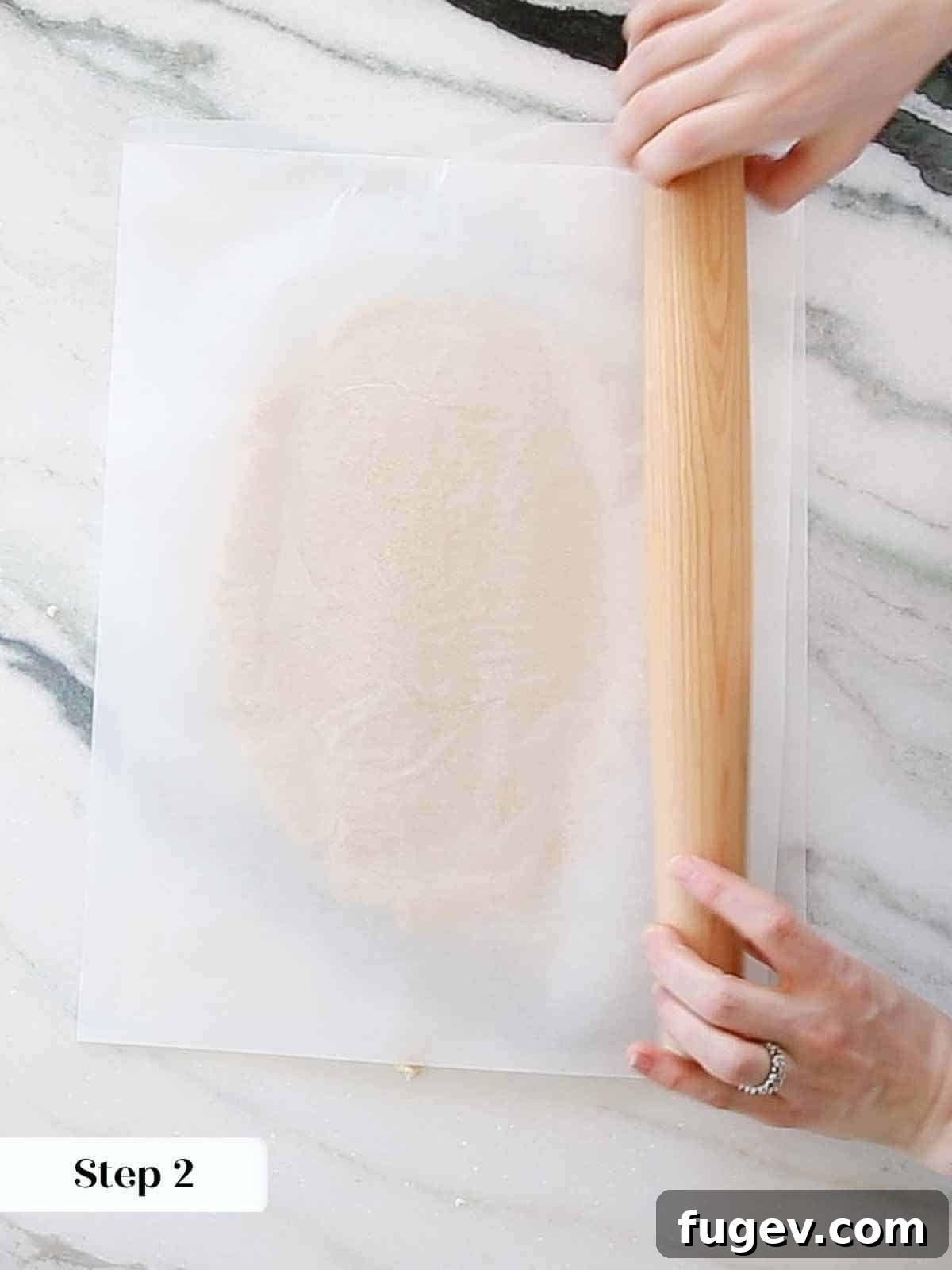 Cupid's Confections 8 Rolling out sugar cookie dough evenly between two sheets of parchment paper.