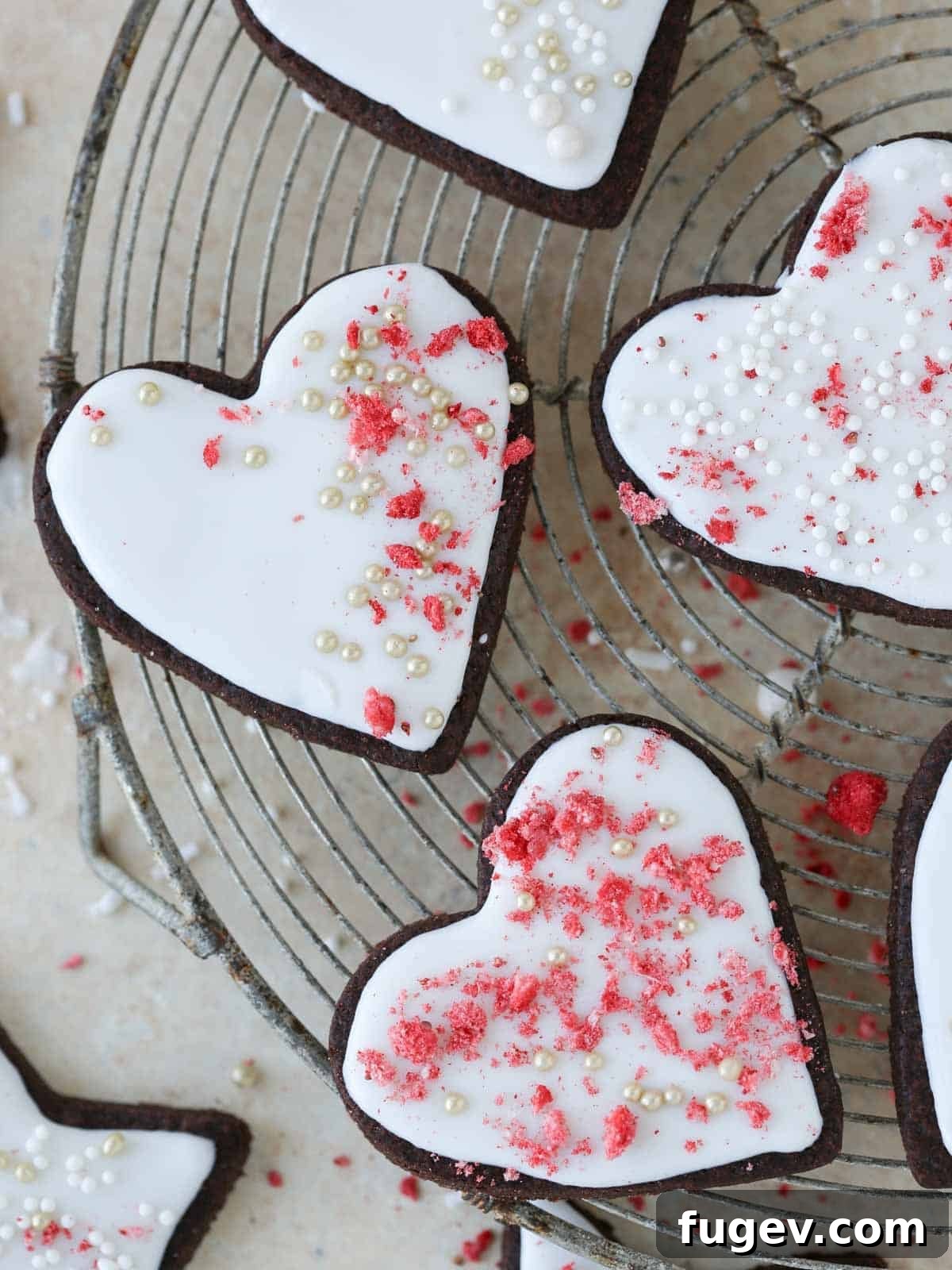 Decadent Chocolate Sugar Delights 2 frosted heart sugar cookies all different on rack.