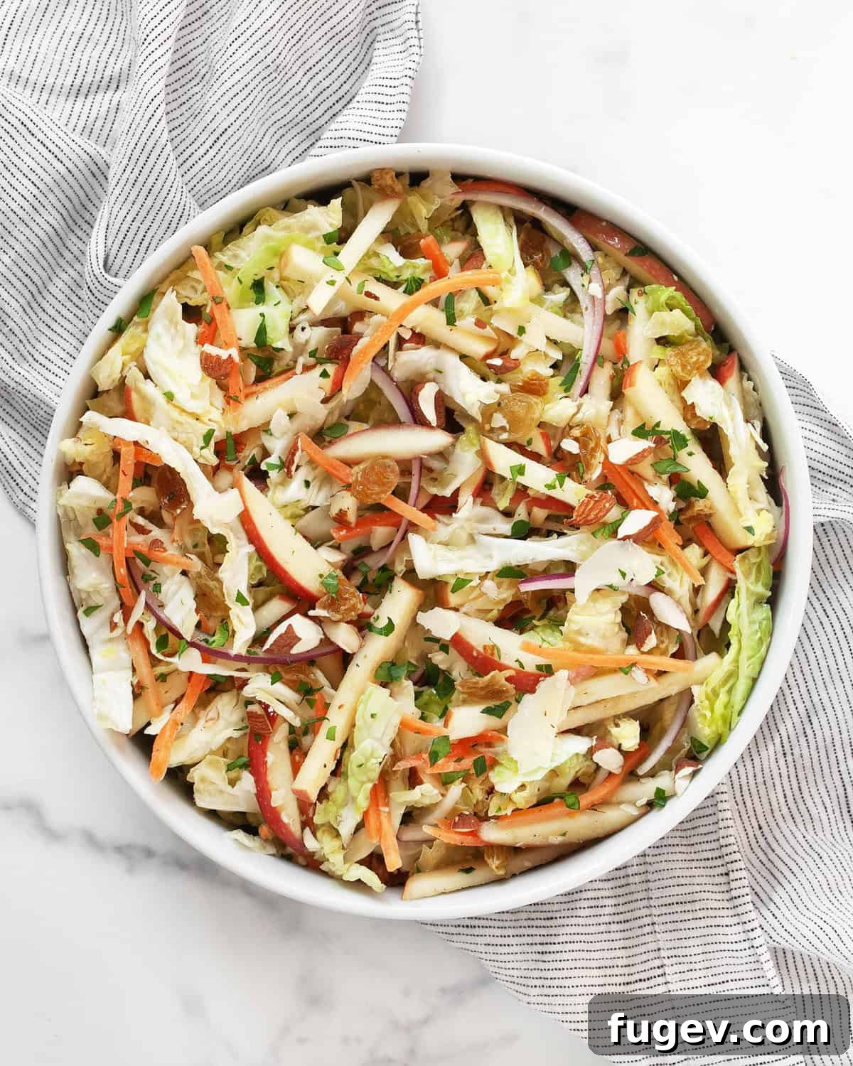 Zesty Savoy Slaw 2 A vibrant Savoy cabbage salad, full of colorful ingredients, served in a rustic ceramic bowl.