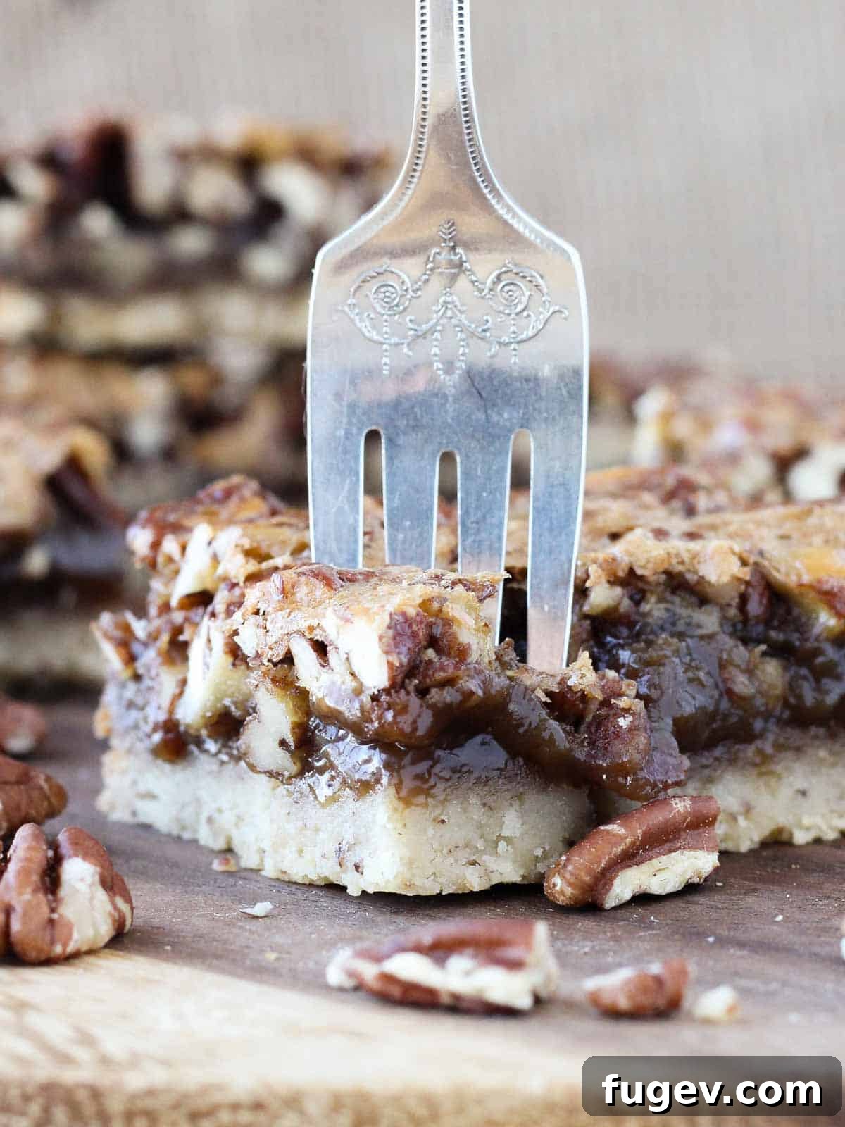 Caramelized Pecan Heaven Bars 4 Close-up of a single pecan pie bar with a fork taking a bite, showcasing the gooey filling and flaky crust.