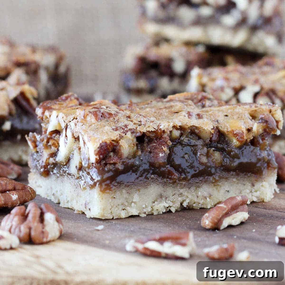 Caramelized Pecan Heaven Bars 5 A perfectly cut square pecan pie bar on a wooden cutting board, showcasing its rich texture.