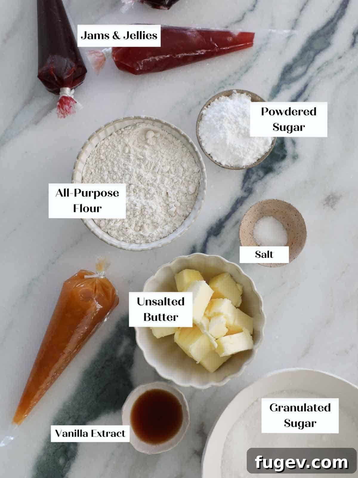Perfectly Jammed Thumbprints 4 A flat lay photograph of the core ingredients for vanilla thumbprint cookies: a stick of butter, a bowl of powdered sugar, a measuring cup of all-purpose flour, a small bowl of kosher salt, and a bottle of vanilla extract, all artfully arranged to showcase their freshness and simplicity.