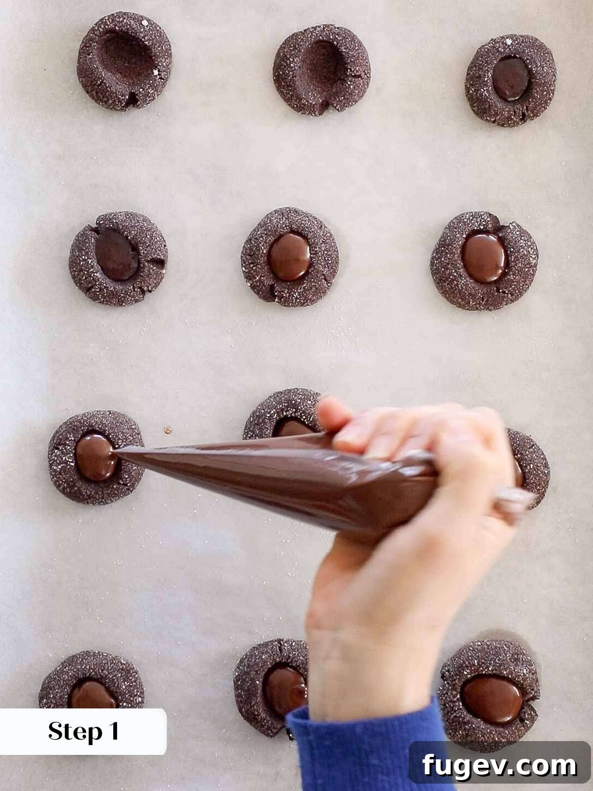 Velvety Chocolate Thumbprint Wonders 14 A piping bag precisely filling baked chocolate thumbprint cookies with chocolate ganache.
