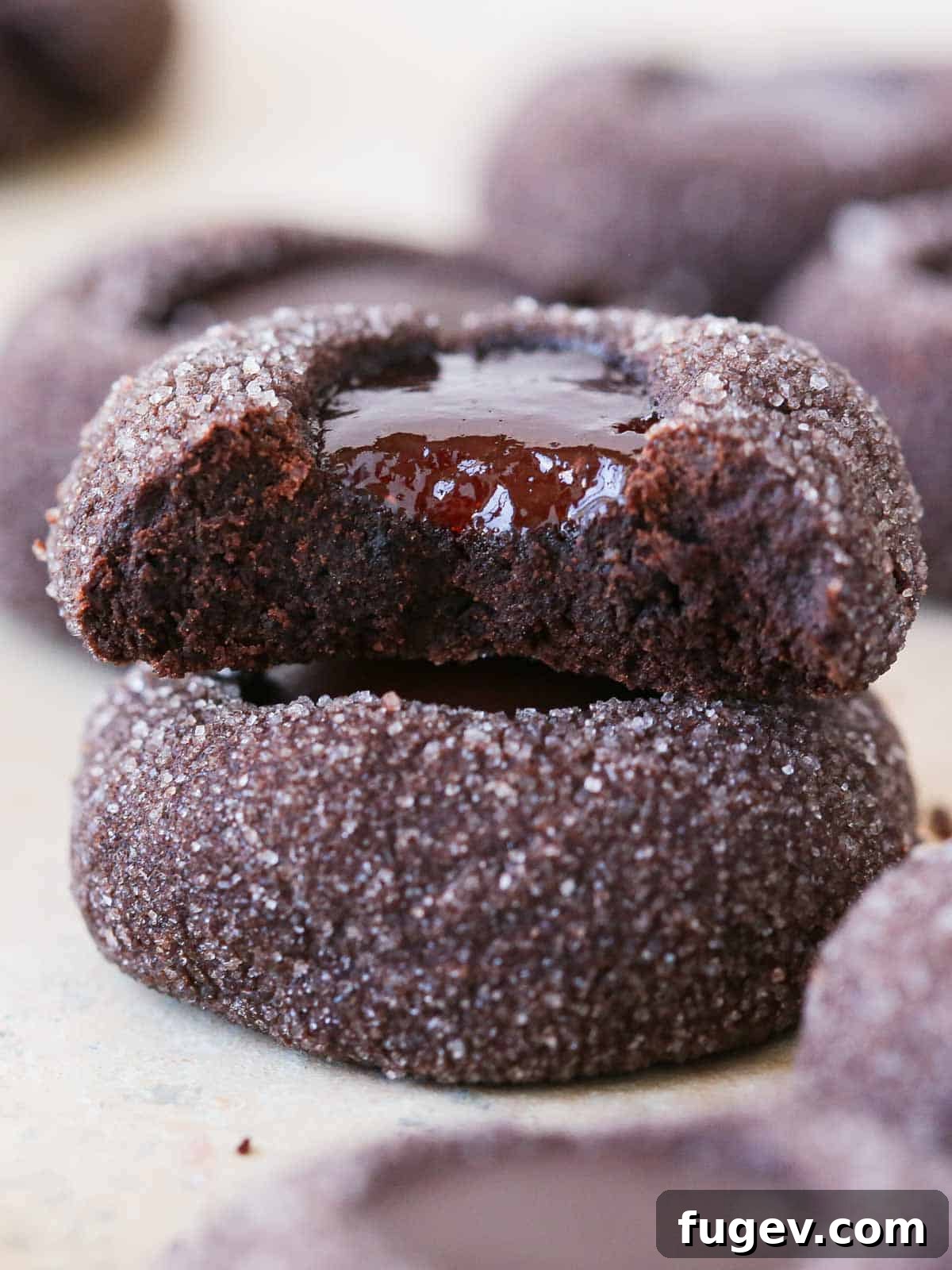 Velvety Chocolate Thumbprint Wonders 3 Neatly stacked jam-filled chocolate thumbprint cookies, showing their perfect indentations and soft, crumbly texture.