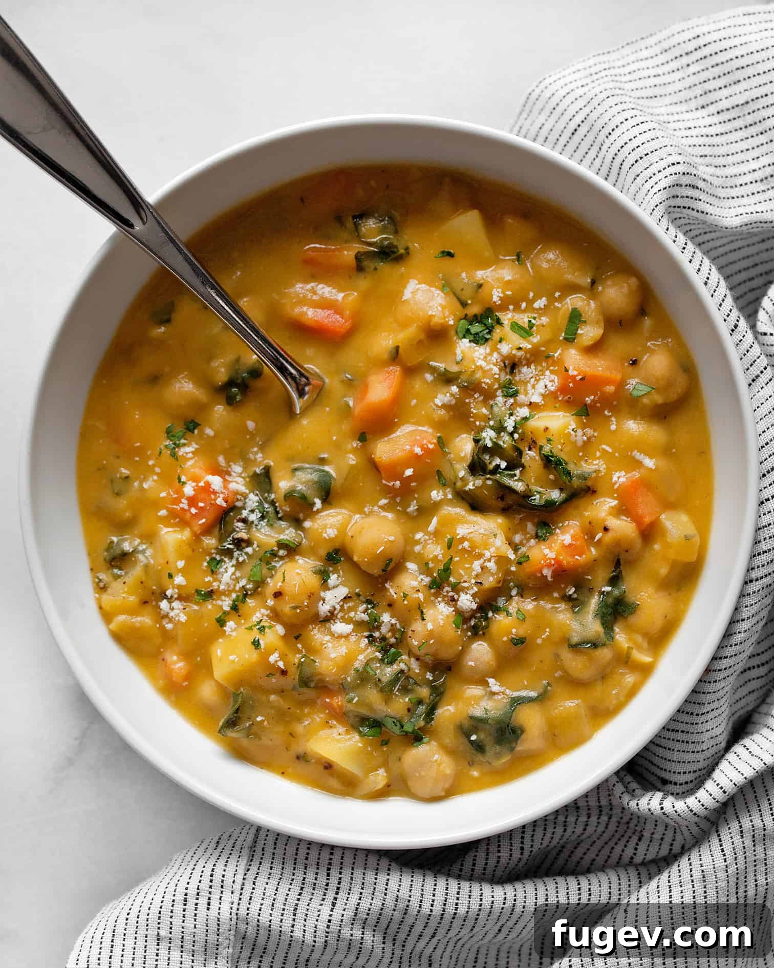 Simple Savory Chickpea Soup 7 A close-up shot of chickpea soup in a rustic bowl, highlighting the garbanzo beans, carrots, and the creamy broth, ready to be enjoyed.