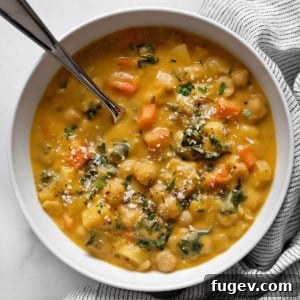 Simple Savory Chickpea Soup 8 A beautifully plated bowl of chickpea soup, showcasing its creamy texture, vibrant vegetables, and fresh herb garnish.