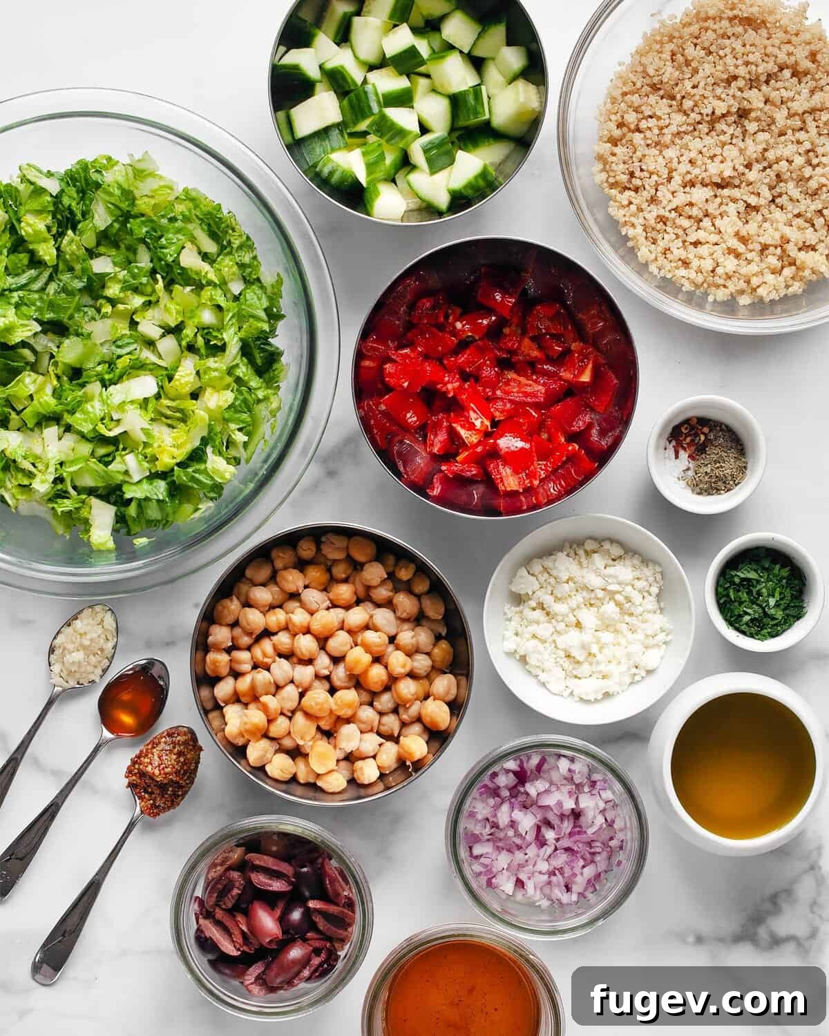 Golden Quinoa Mediterranean Delight 3 Assortment of fresh ingredients for Mediterranean salad: romaine lettuce, cucumbers, sun-dried tomatoes, chickpeas, red onions, feta, parsley, garlic, olive oil, and red wine vinegar.