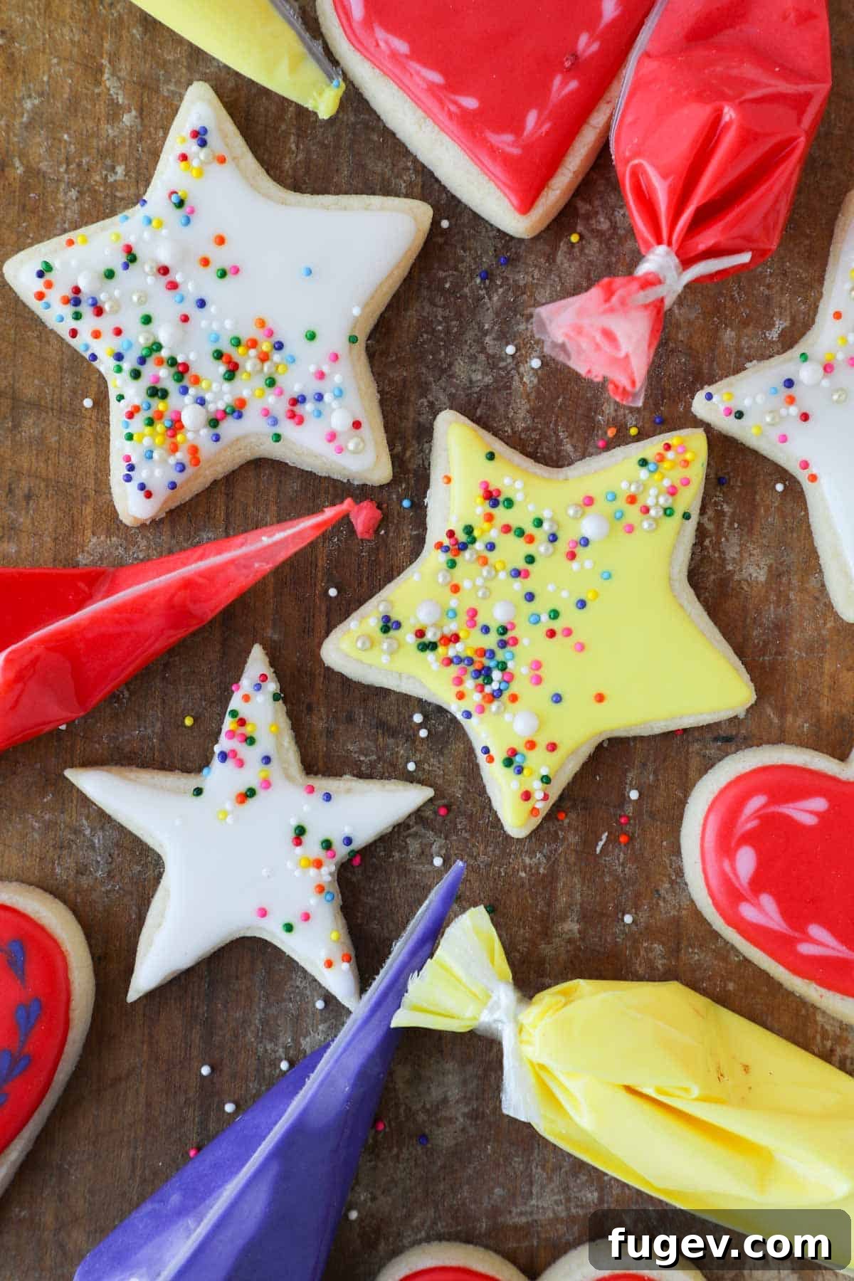 Foolproof Royal Icing with Meringue Powder 2 Beautifully iced star-shaped cookies in yellow and white, arranged on a rustic wooden surface, showcasing the smooth, shiny finish of royal icing.
