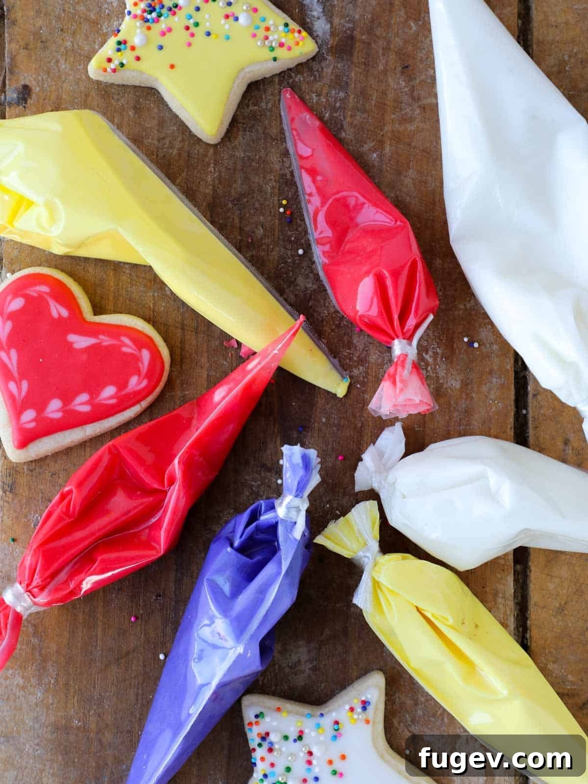 Foolproof Royal Icing with Meringue Powder 3 A vibrant collection of piping bags filled with red, purple, yellow, and white royal icing, ready for intricate cookie decoration.