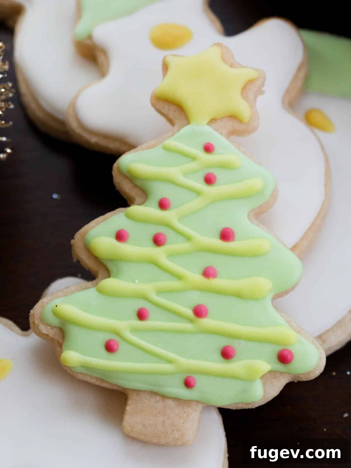 Foolproof Royal Icing with Meringue Powder 5 A Christmas tree-decorated sugar cookie, showcasing the results of royal icing colored with liquid food dye – softer hues and potentially less definition.