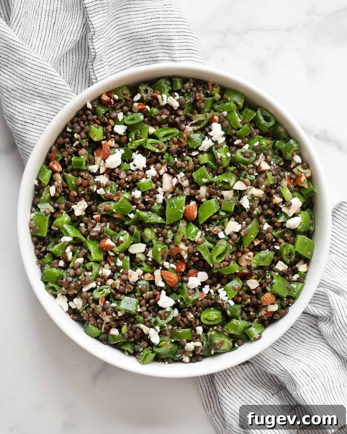 Crunchy Snap Pea and Lentil Delight 2 A vibrant snap pea lentil salad elegantly presented in a bowl, showcasing fresh ingredients.
