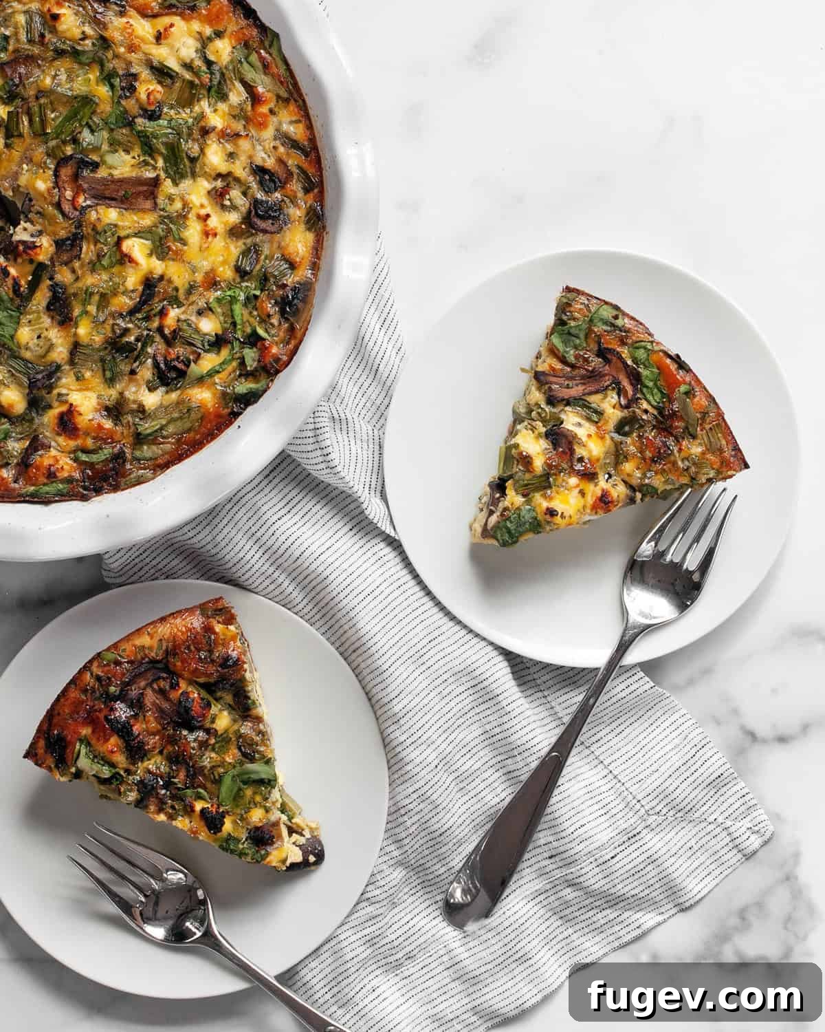 Roasted Asparagus and Creamy Cottage Cheese Frittata 7 A close-up shot of the roasted asparagus cottage cheese egg bake, perfectly cut into two generous slices, revealing the vibrant layers of vegetables and creamy egg inside.