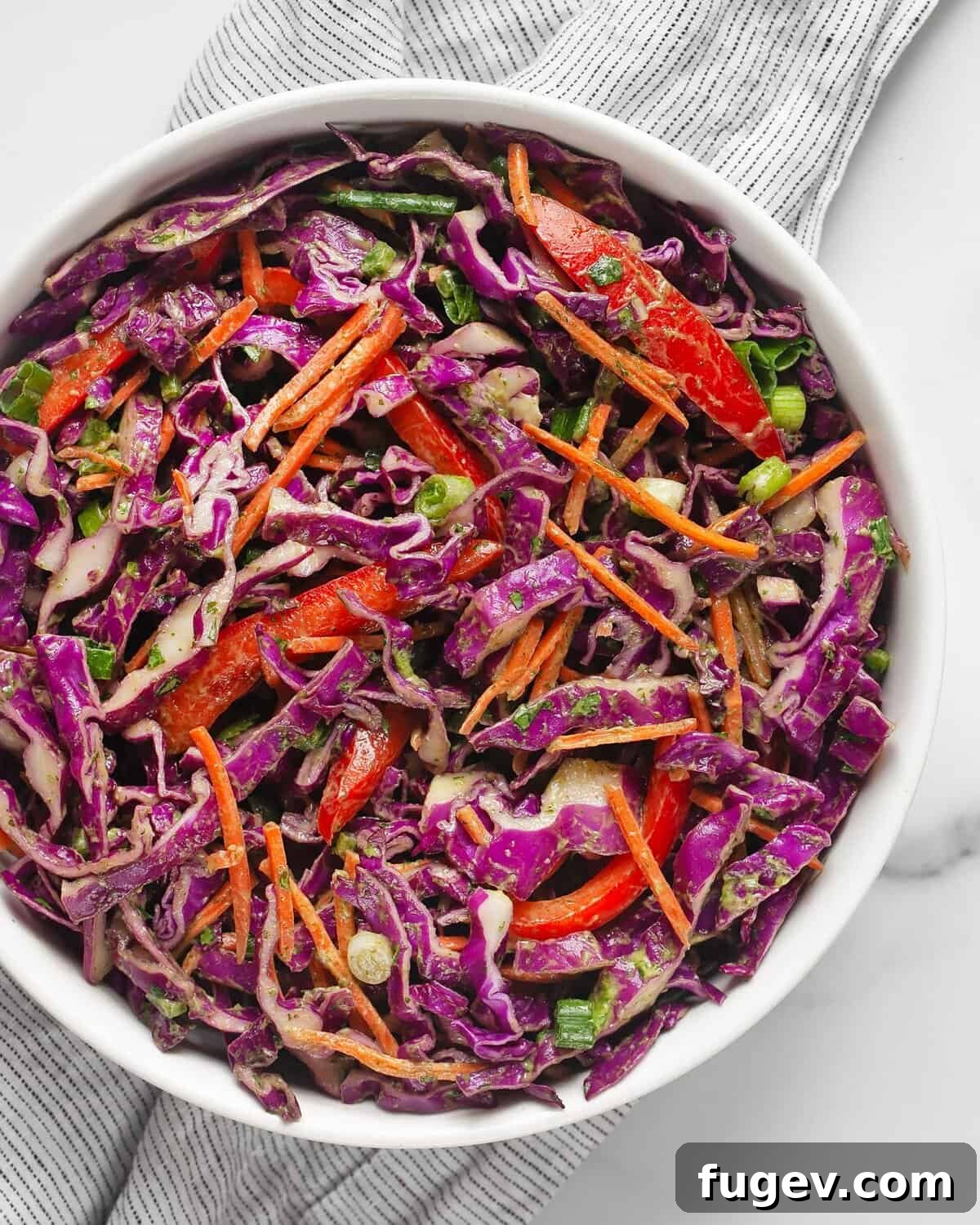 Vibrant Red Cabbage Slaw 2 A large, inviting bowl filled with vibrant red cabbage slaw, showcasing its rich colors and inviting texture. Fresh lime wedges are placed alongside, hinting at the zesty dressing.