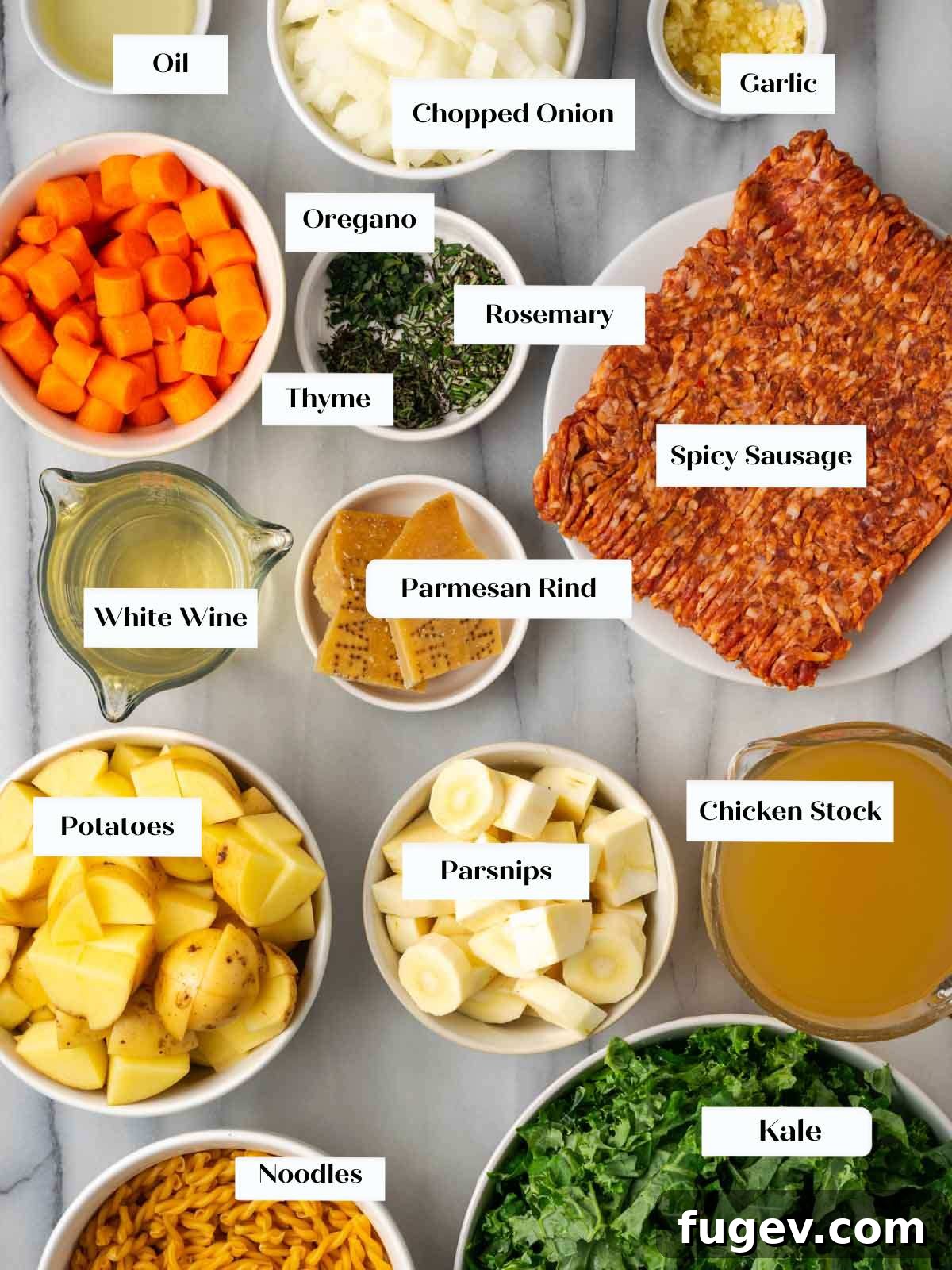 Hearty Italian Sausage Soup 4 Fresh ingredients for Italian sausage soup meticulously laid out on a marble countertop: vibrant onions, garlic cloves, bright carrots, fresh herbs, spicy Italian sausage, and a block of Parmesan cheese with its rind.
