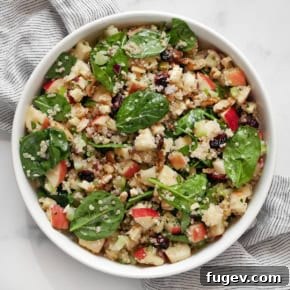 Apple salad with quinoa and baby spinach in a bowl.
