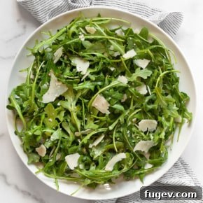 Baby arugula salad on a plate with lemon dressing.