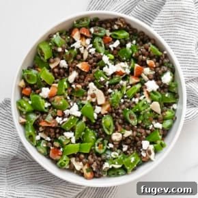 Snap pea lentil salad in a bowl with goat cheese.