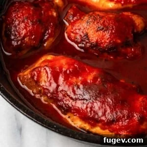 cooked bbq chicken breast in skillet.