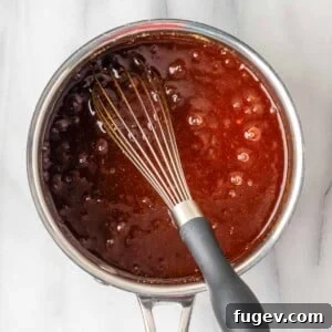 Homemade BBQ sauce simmering gently, capturing its rich texture and color.